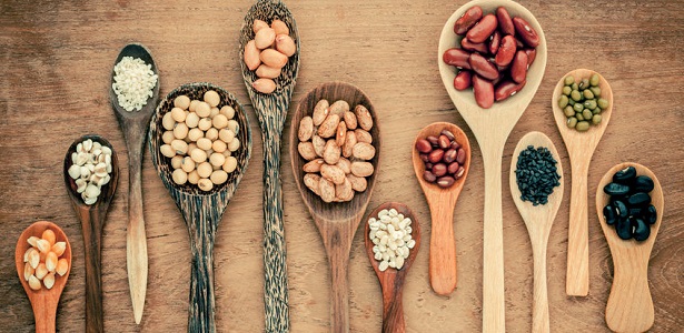 assortment of beans and lentils in wooden spoon on teak wood background. mung bean, groundnut, soybean, red kidney bean , black bean ,sesame, corn ,red bean and brown pinto beans .