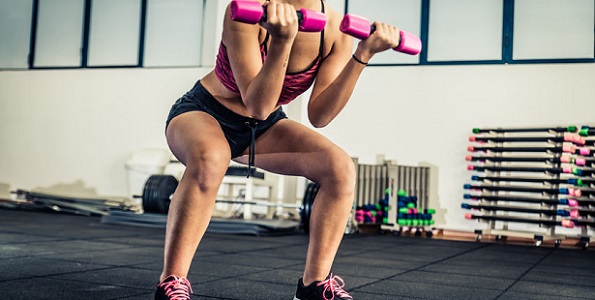 athletic young woman doing squat exercises for the buttocks